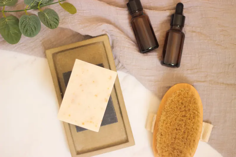 Calming spa setup featuring natural soap, essential oils, and foliage for a relaxing atmosphere