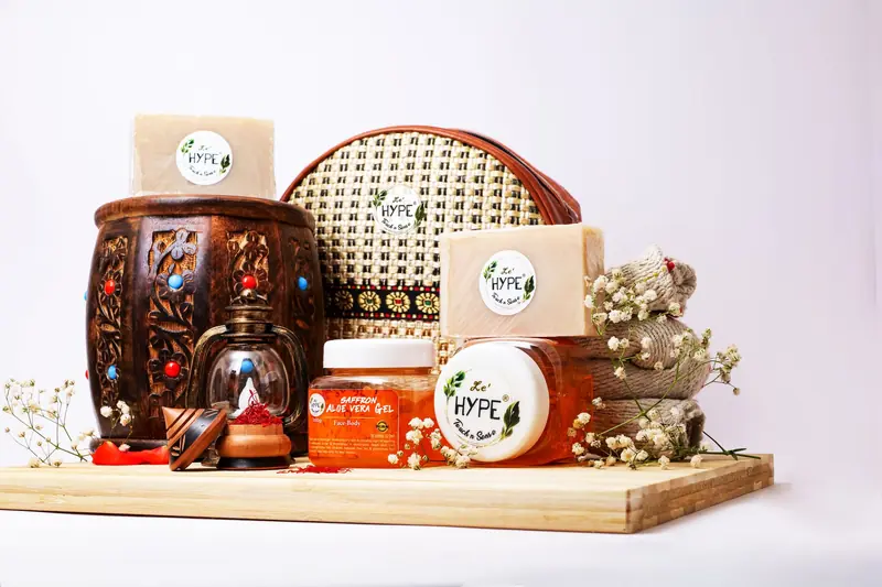 A collection of natural skincare products with herbal soap and accessories on a wooden background