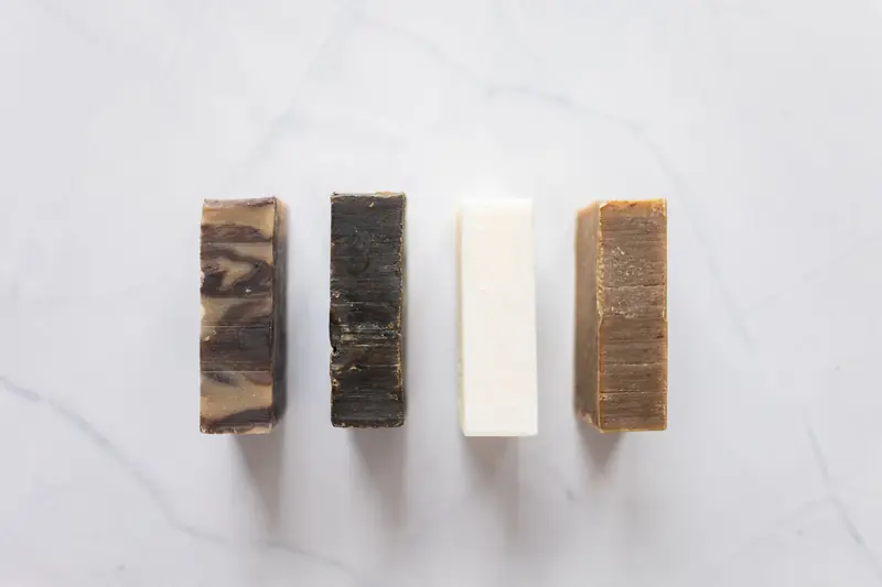 Top view of composition with handmade aromatic soap placed on white background in bathroom