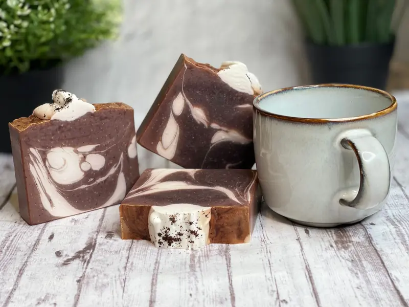 Artisan chocolate swirl soap bars with a rustic ceramic mug on wooden table