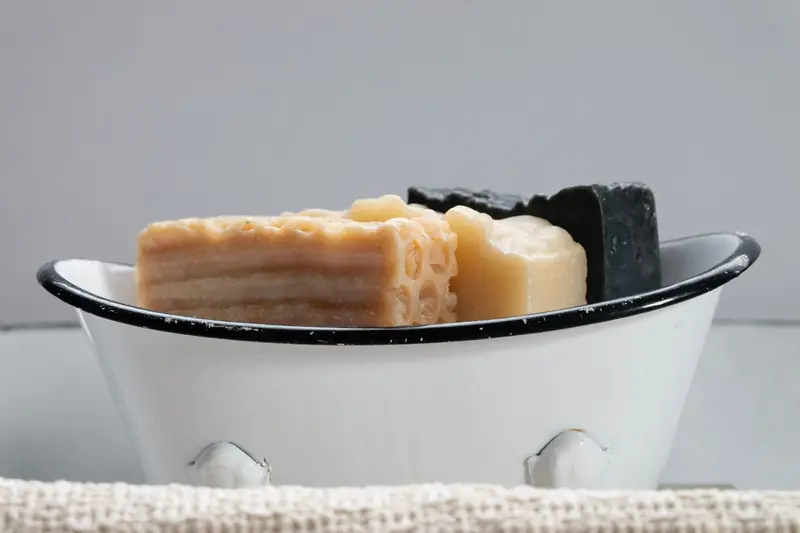 Close-up of assorted handmade soaps in a vintage soap dish