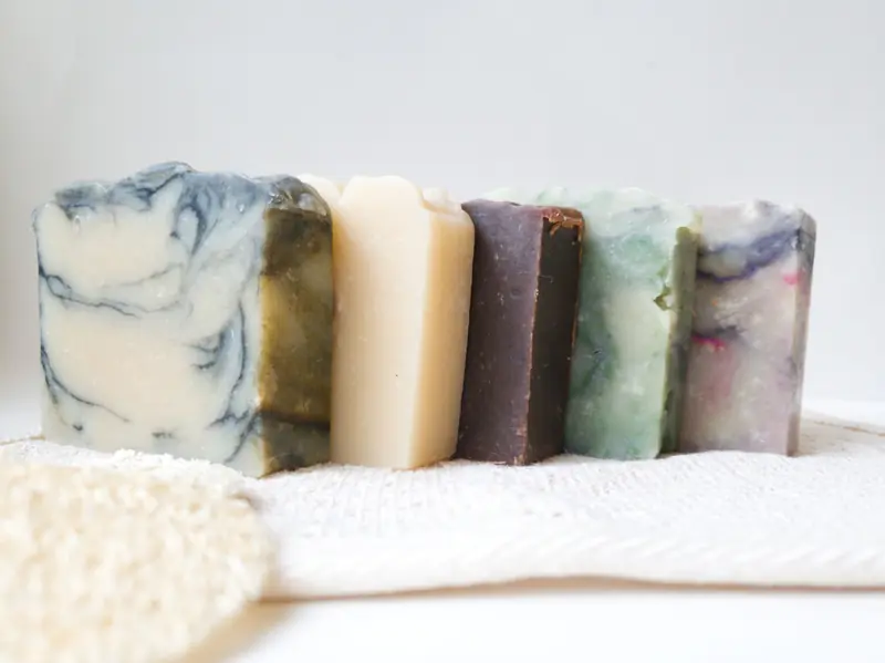 Close-up of various handmade soaps on a textured fabric, showcasing natural beauty and skincare