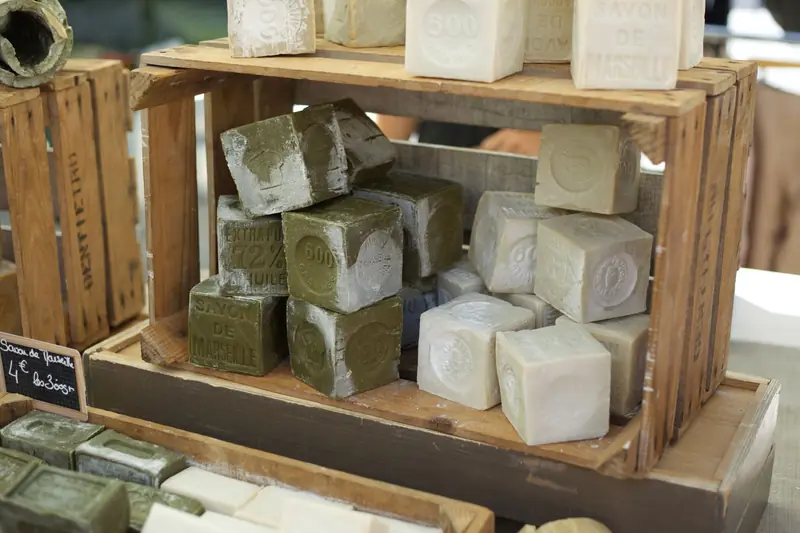 Handcrafted soap blocks on wooden shelves at a local market stall