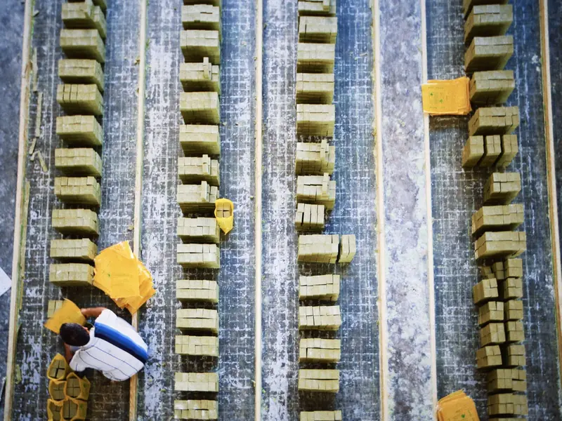 Aerial shot of a worker in a soap factory organizing bars of soap on production lines