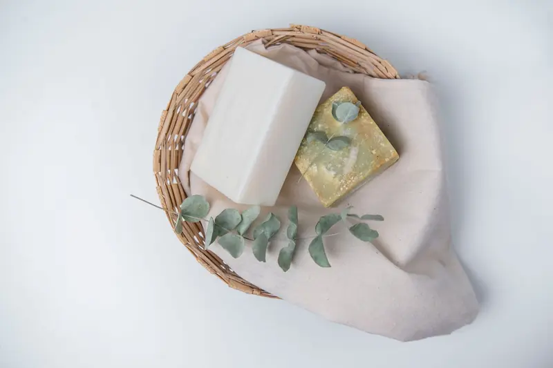 A natural, eco-friendly soap set with eucalyptus in a wicker basket, perfect for organic lifestyle promotions