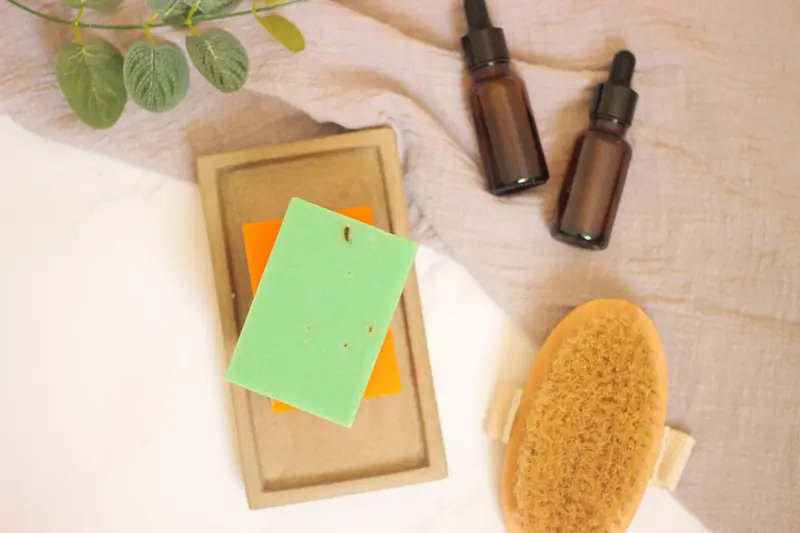 Flat lay of spa essentials with handmade soap and essential oils for a calming treatment