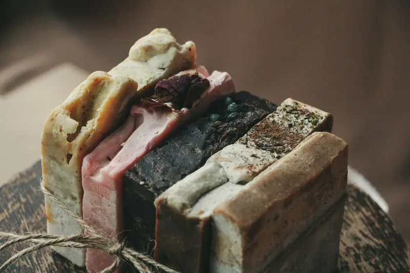 A rustic stack of handmade organic soap bars tied with twine on a wooden surface