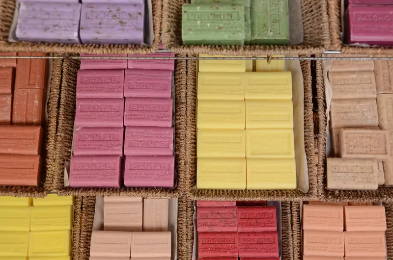 A vibrant display of handmade soaps in various colors and scents at a market